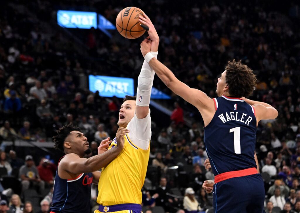 Lakers center Walker Kessler, middle, is fouled by Clippers guard...