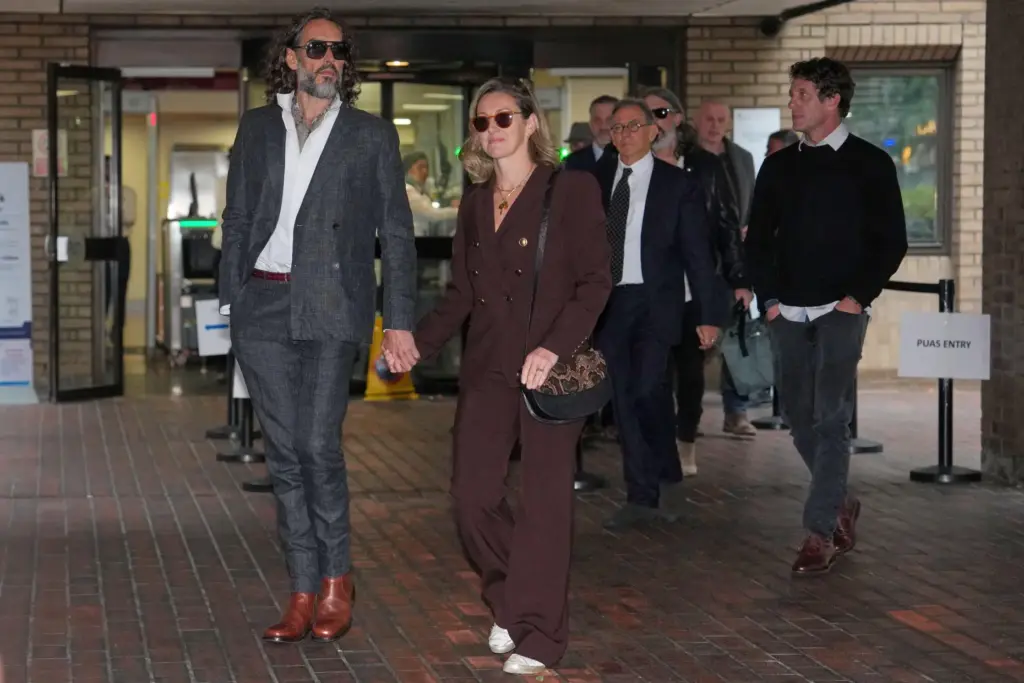 Russell Brand, accompanied by his wife Laura Brand, leaves Southwark Crown Court.
