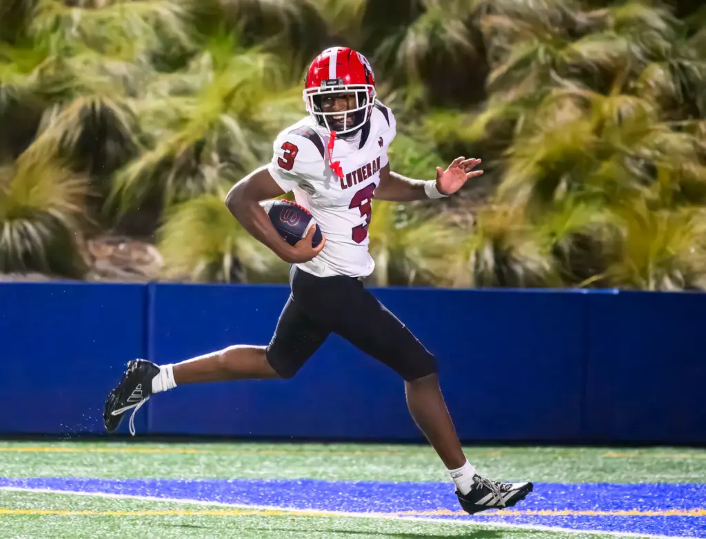 Orange Lutheran free safety Chauncey Washington II runs into the...