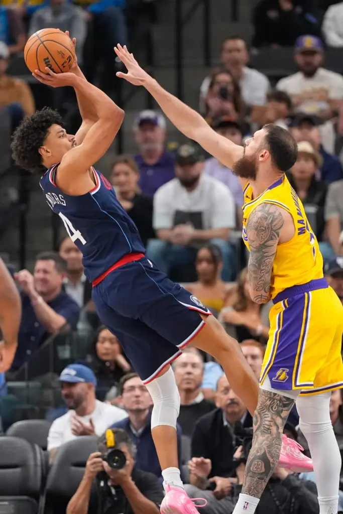 Clippers guard Kobe Sanders, left, shoots as Lakers forward Sandro...