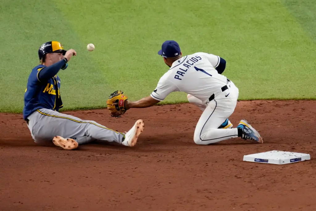 The Milwaukee Brewers’ Cooper Pratt, left, is caught trying to...