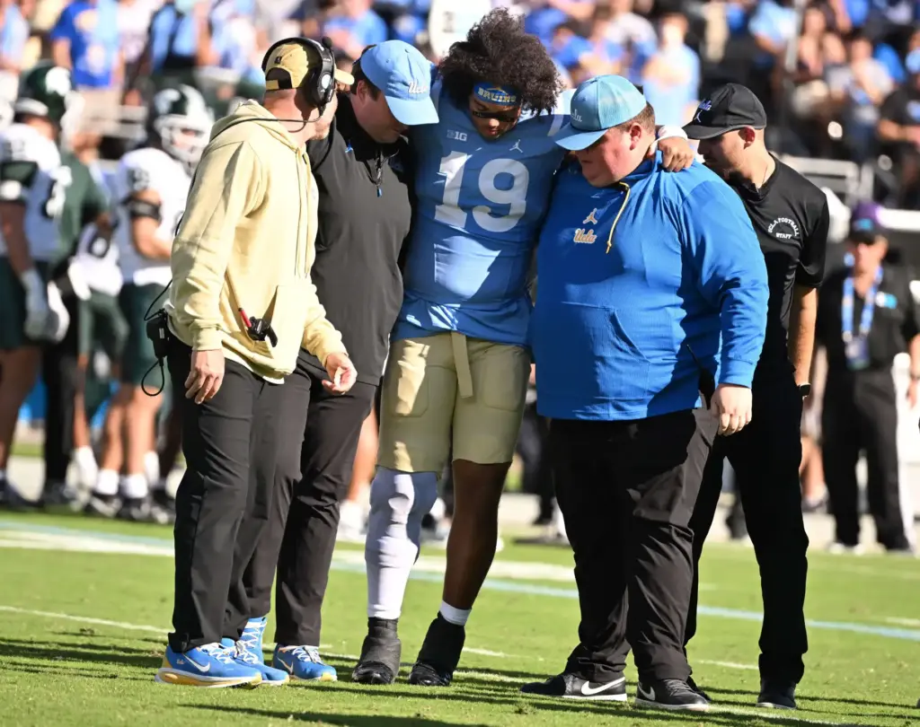UCLA linebacker Ryan McCulloch (19) is helped off the field...