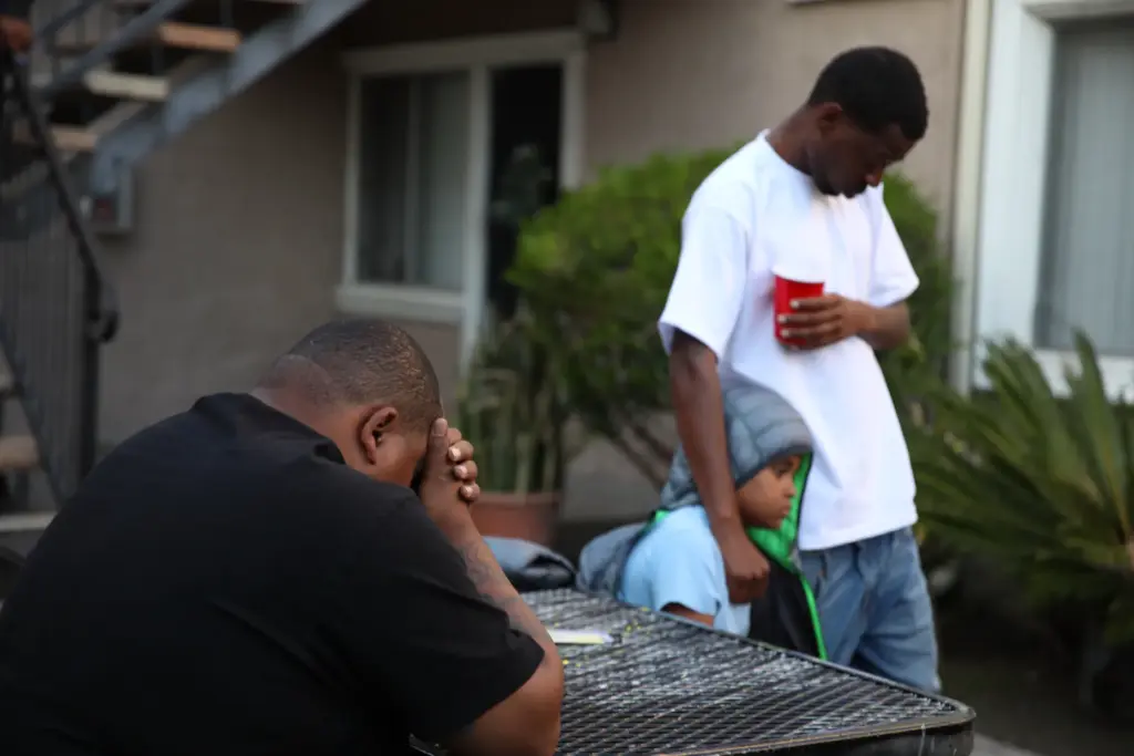 Family, friends and neighbors attend a candlelight vigil in Long...
