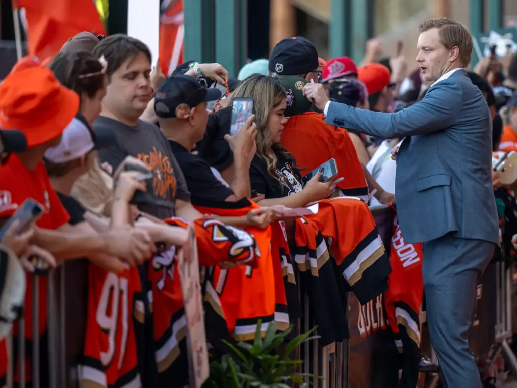 Ducks goaltender Ville Husso signs autographs on the orange carpet...