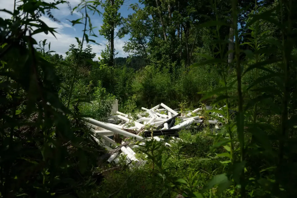 Workers from MountainTrue clear IPEX PVC pipe from the riverbank...