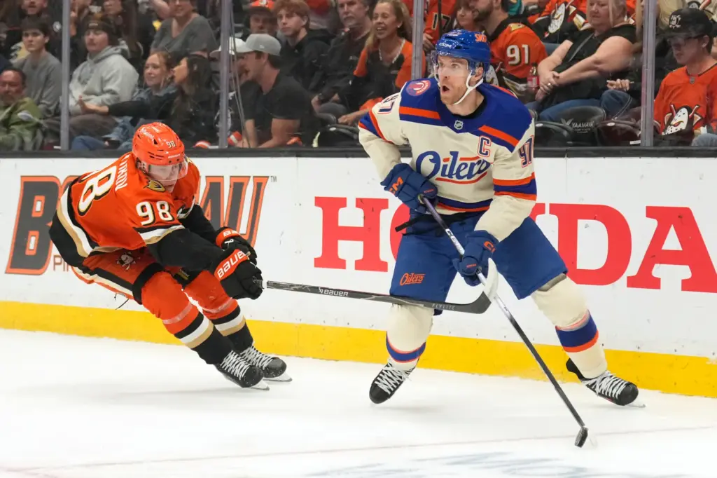Edmonton Oilers center Connor McDavid, right, tries to pass the...