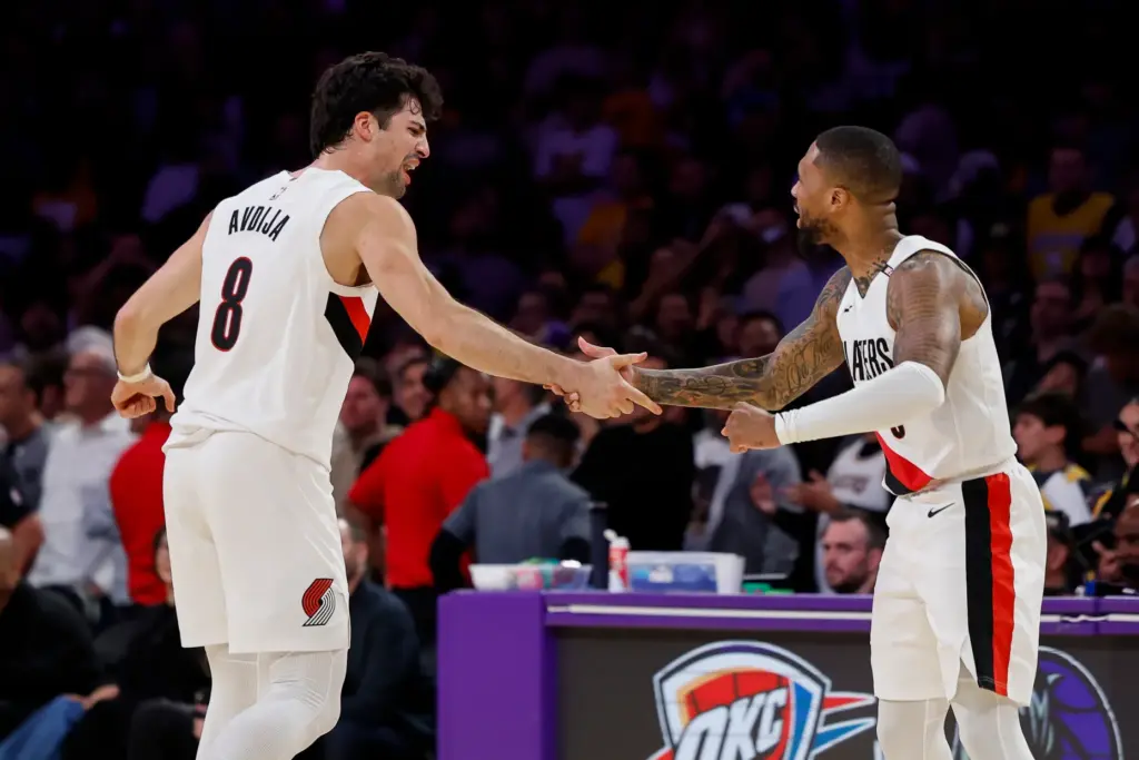 Portland Trail Blazers guard Damian Lillard, right, is greeted by...