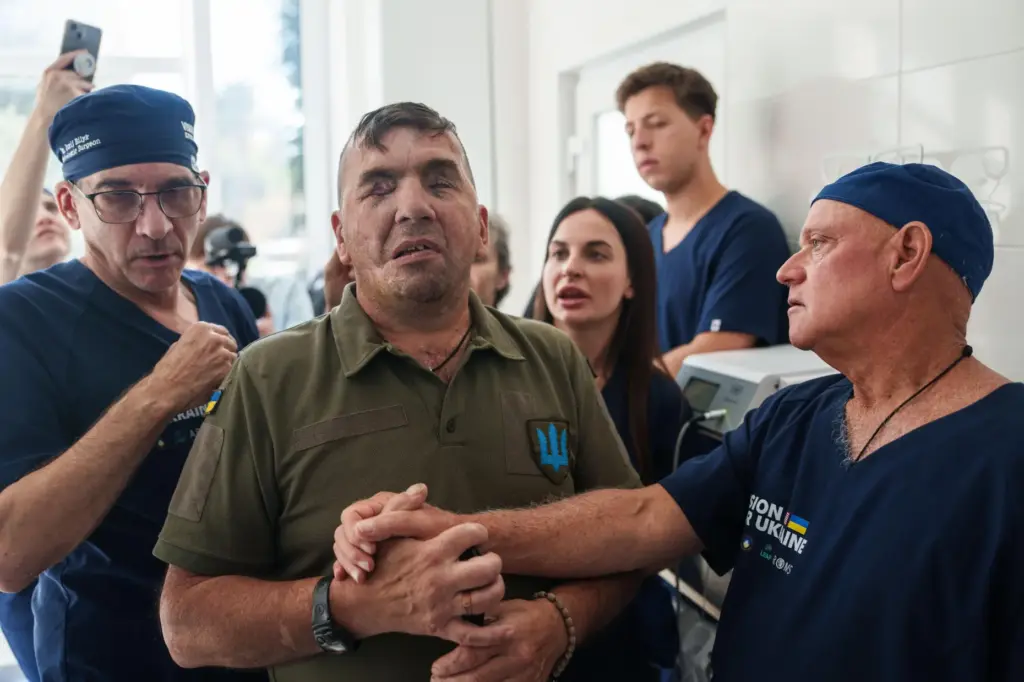 Stuart Seiff, a U.S. oculoplastic surgeon, speaks to wounded soldier Mykola Kasiuk.