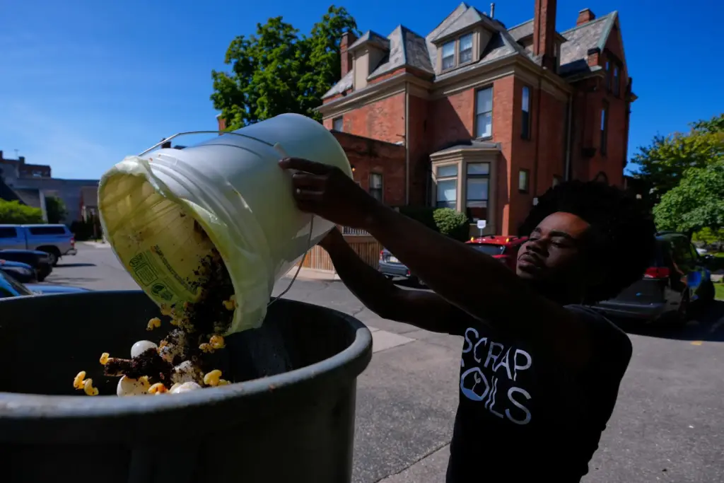 Ricky Blanding, founder of Scrap Soils, collects compostable material at...