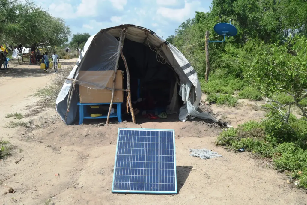 FILE – A family displaced by flooding has a solar...