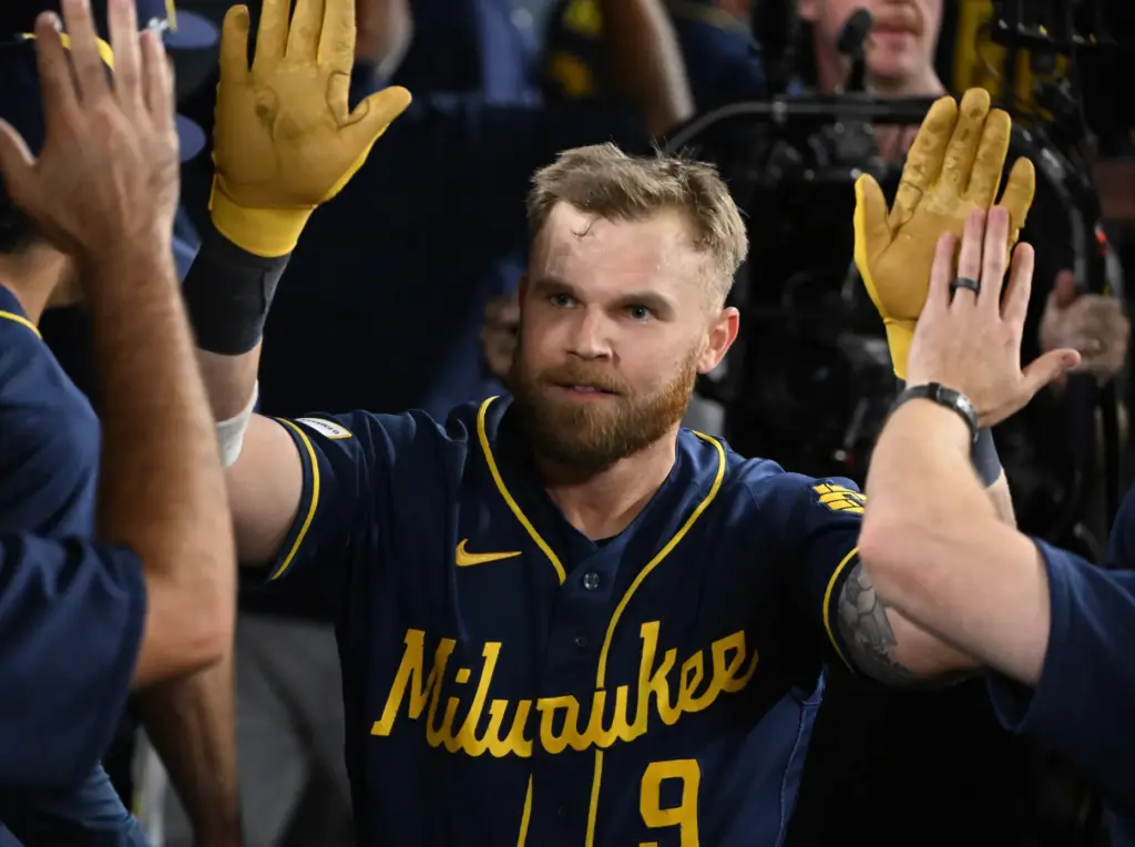 The Milwaukee Brewers’ Jake Bauers celebrates in the dugout after...