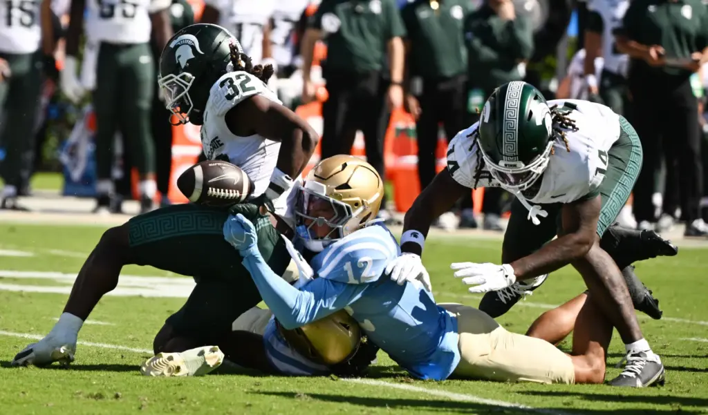 UCLA defensive back Malik Hartford (12) forces a fumble by...