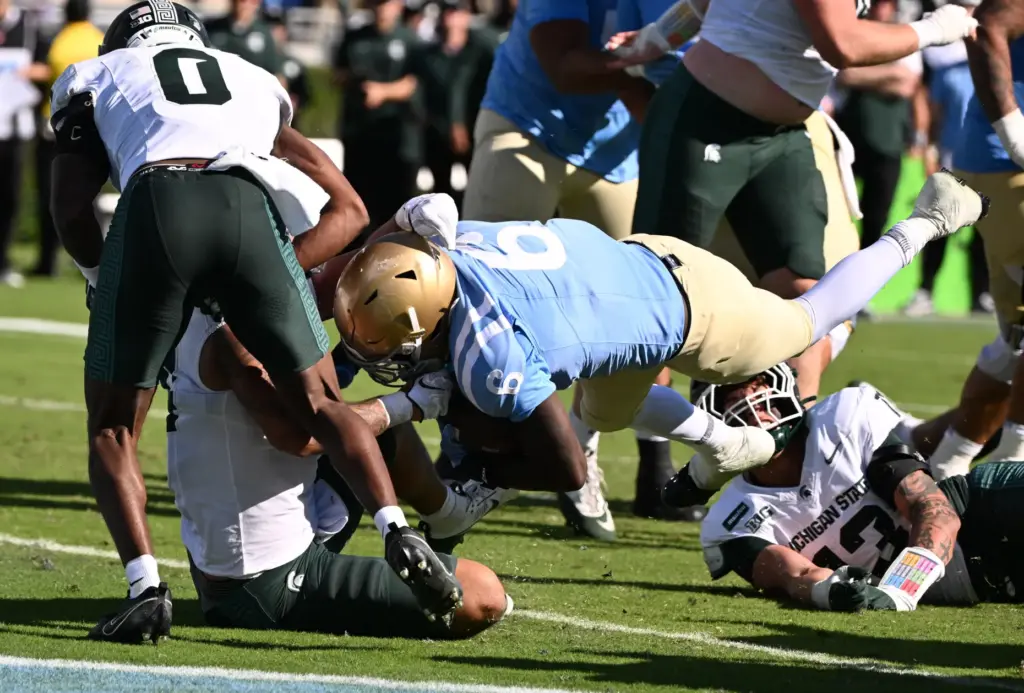 UCLA running back Anthony Woods (6) dives for a 4-yard...