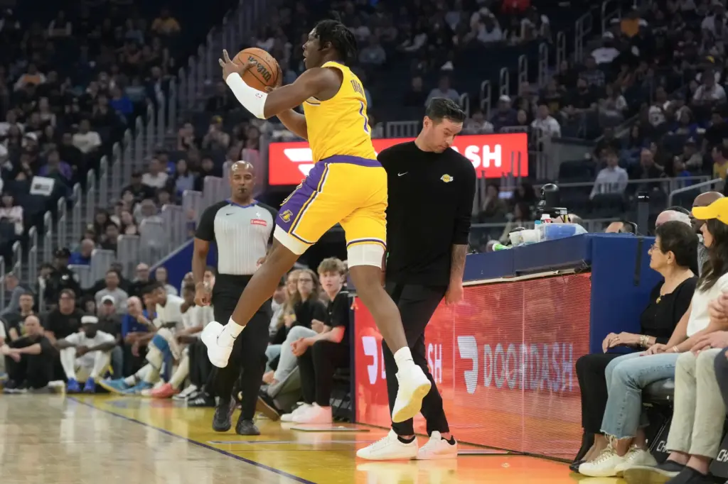 Lakers forward Adou Thiero, left, saves the ball from going...