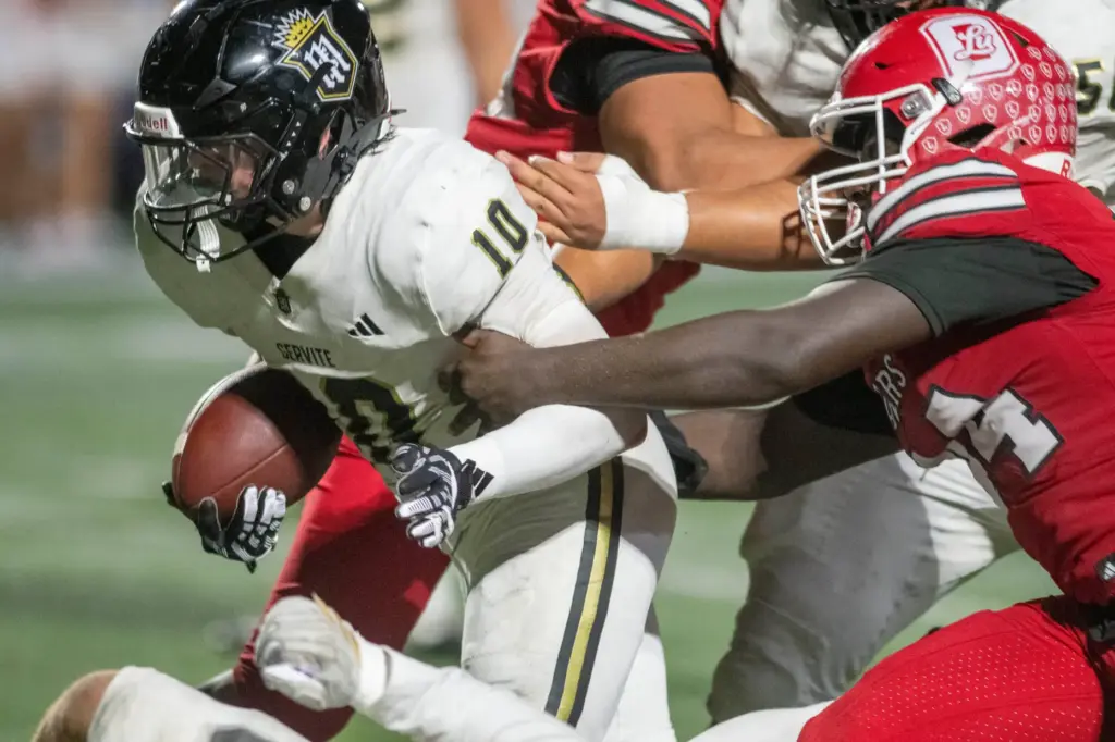 Serviteâs Parker Covin (10) battles his way into the end...