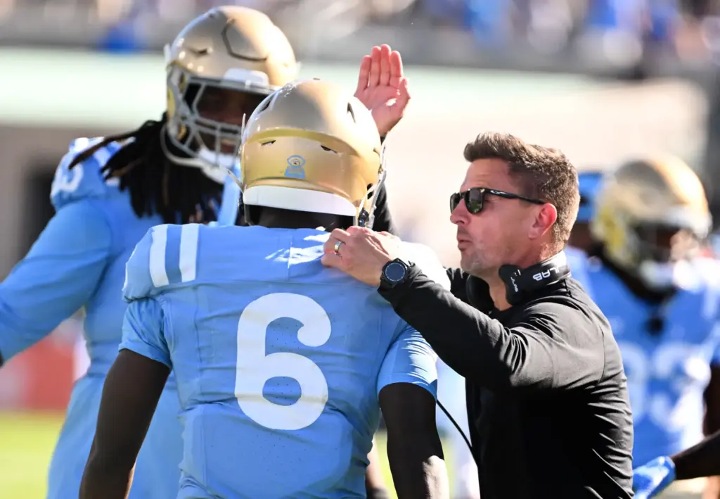 Head coach Bob Chesney of the UCLA Bruins pats running...