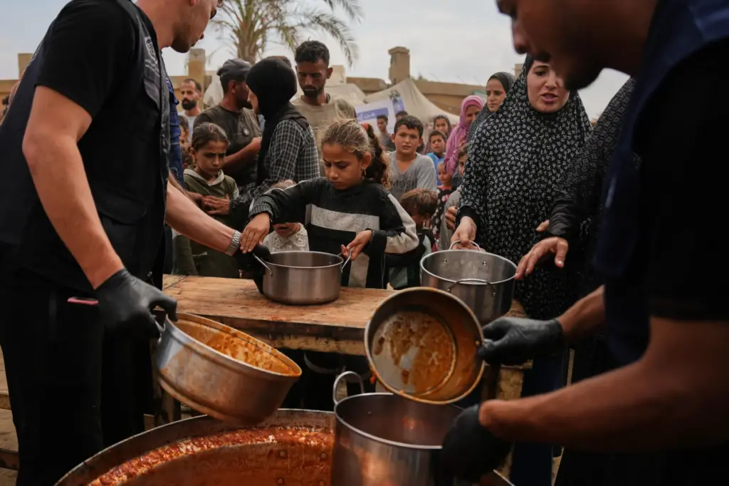 Palestinians receive food donated by the World Food Programme at...