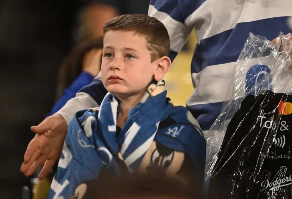 A young Dodgers fan looks on during the ninth inning...