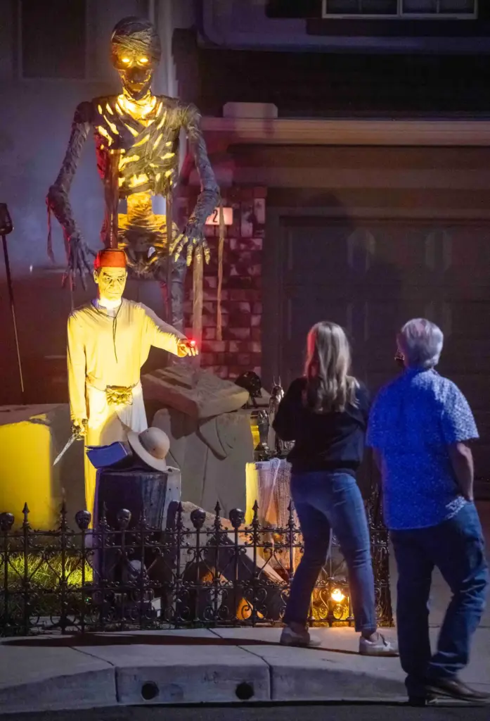 Neighbors walk by a display featuring The Mummy from the...