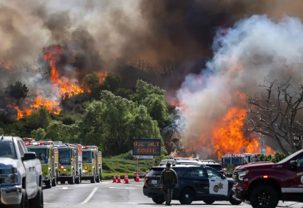Orange County Fire Authority firefighters monitor flames on the north...