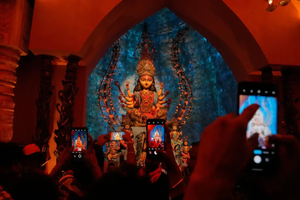 FILE – People take photos of an idol of Hindu...