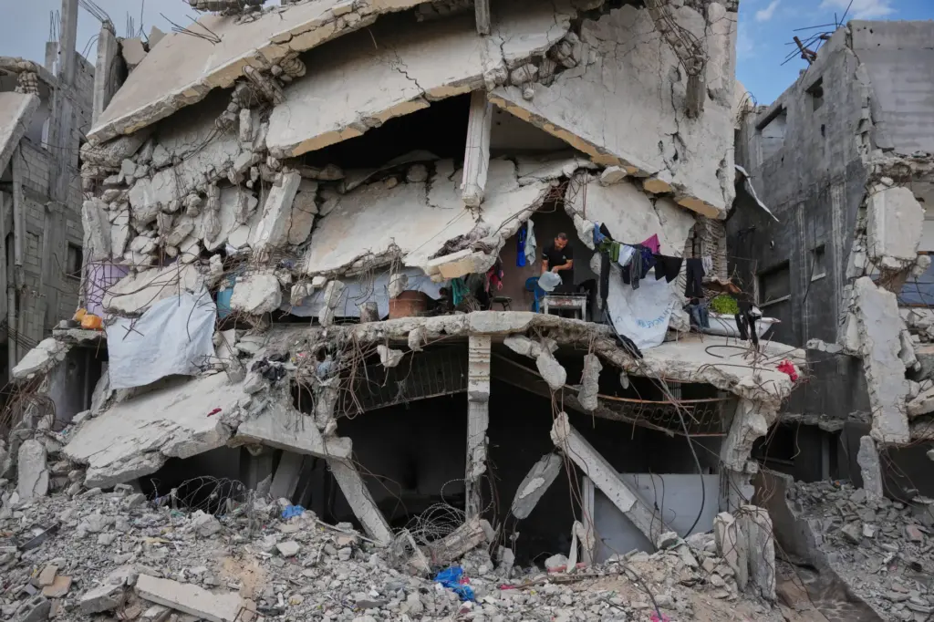 Murid Akhziq lights a fire inside his home, which was destroyed during the Israel-Hamas war.