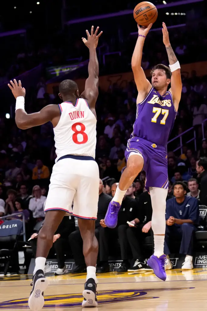 Lakers star Luka Doncic, right, shoots as Clippers guard Kris...