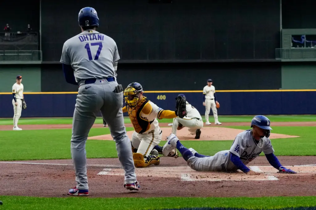 The Dodgers’ Mookie Betts, right, slides home to score on...