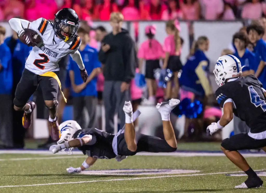 Huntington Beachâs Dylin Bruce (2) hurdles a defender as he...