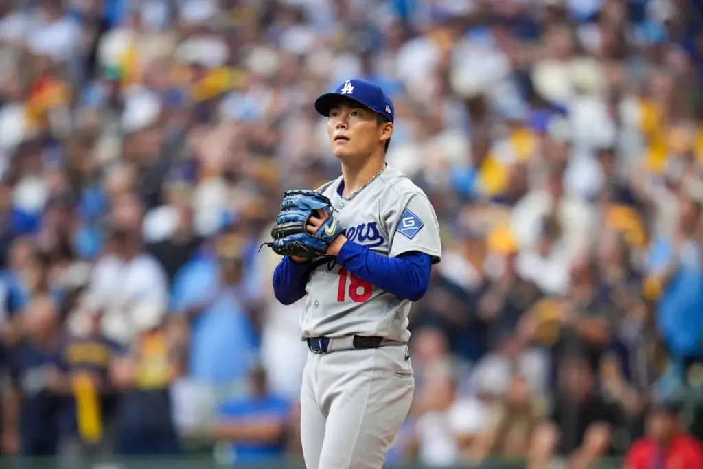 Dodgers starting pitcher Yoshinobu Yamamoto looks away after walking a...