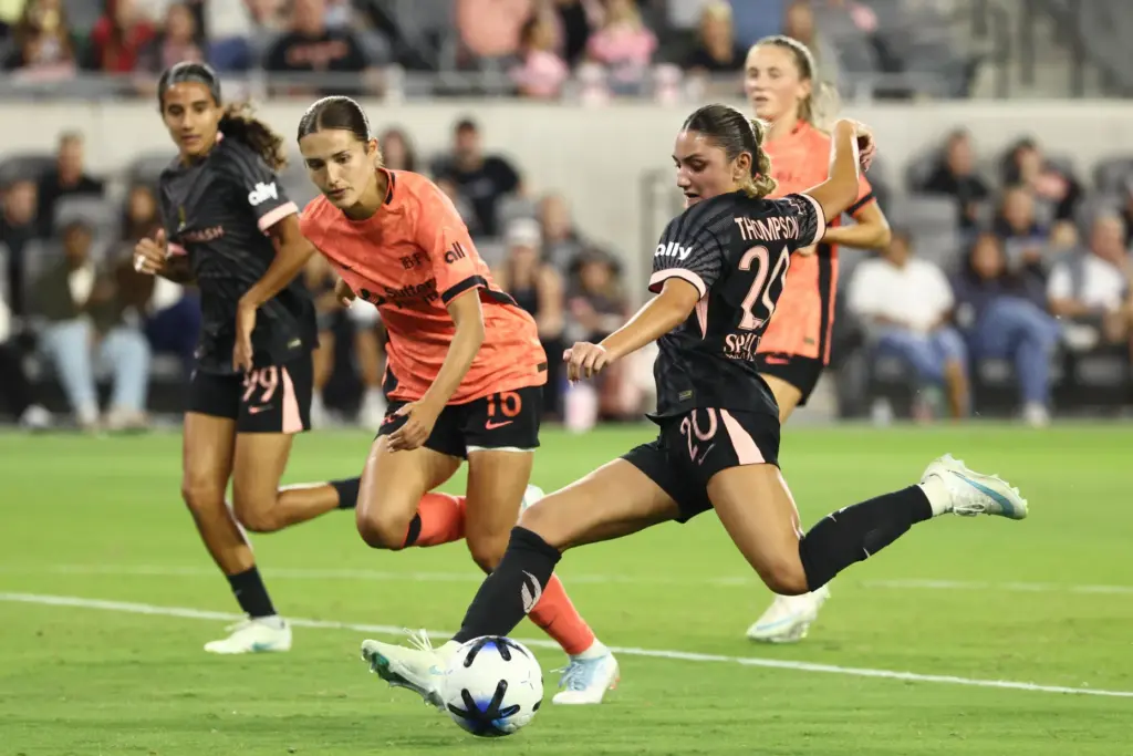 Angel City FC defender Gisele Thompson, right, winds up to...
