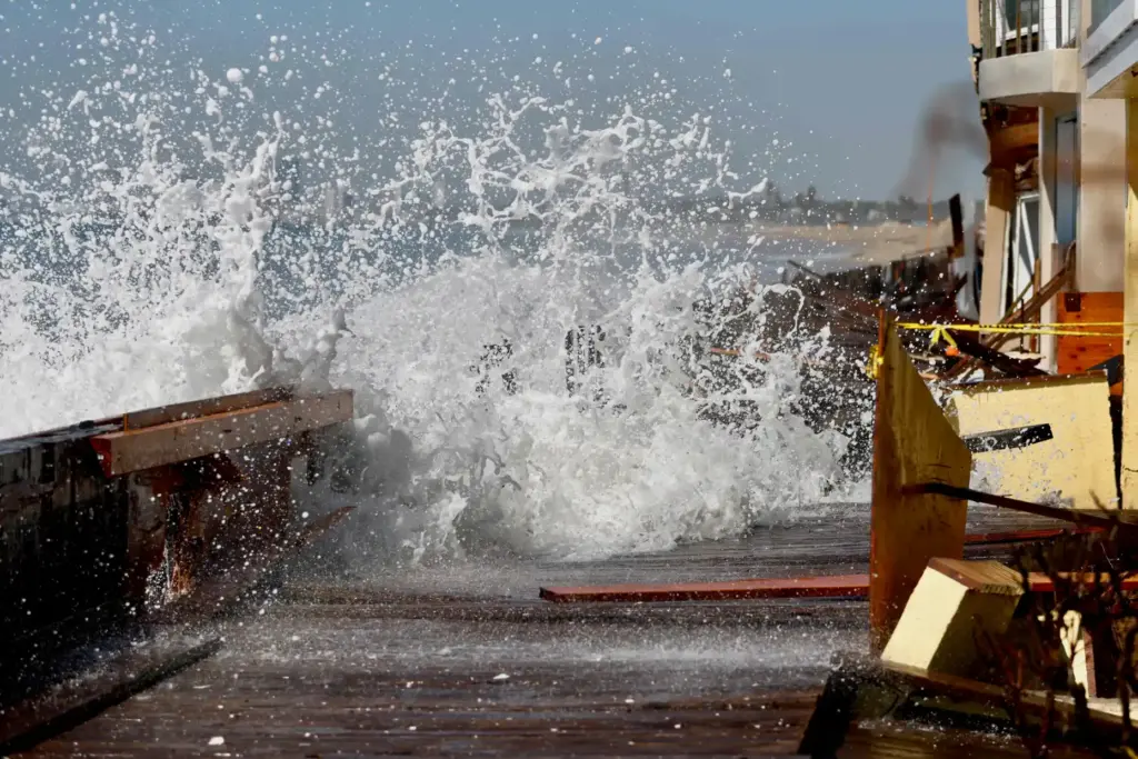 High surf breaches the boardwalk along the Peninsula in Long...