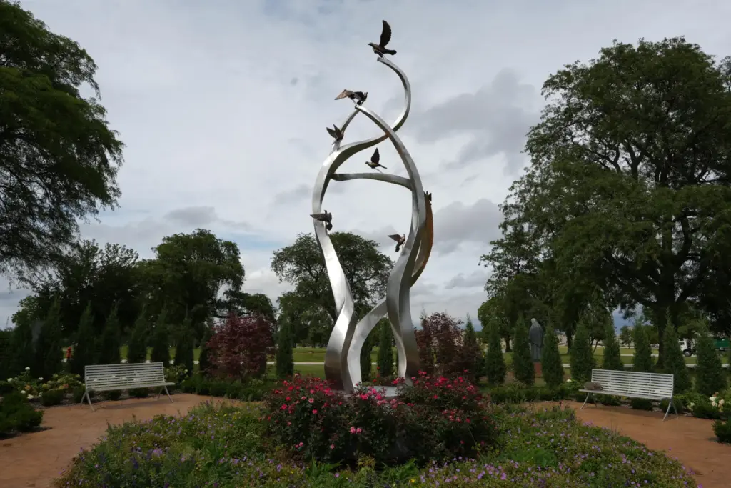 A sculpture of ascending doves is displayed at a memorial...