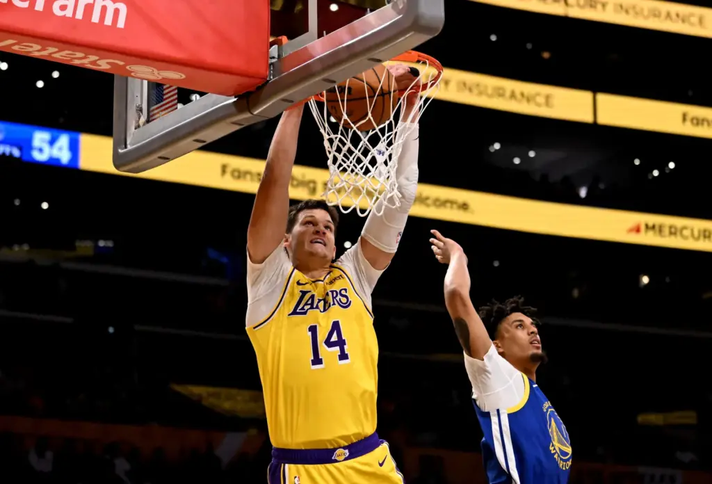 Lakers center Walker Kessler dunks in front of Golden State...