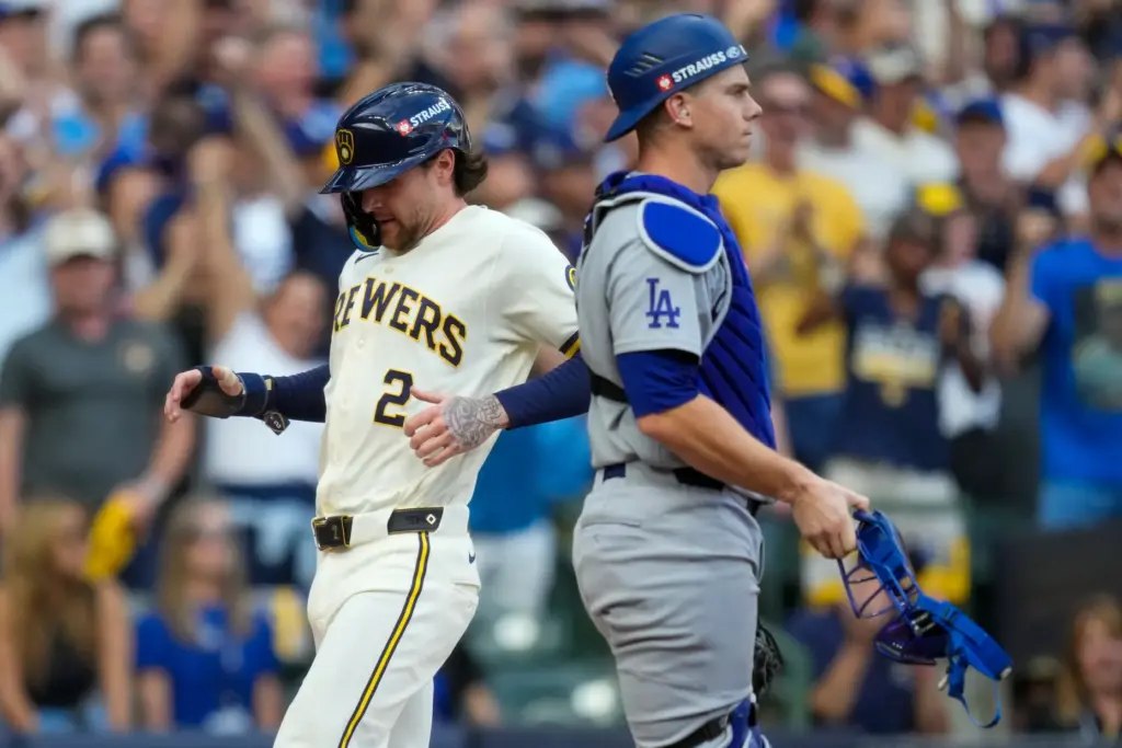 The Milwaukee Brewers’ Brice Turang, left, scores on a sacrifice...