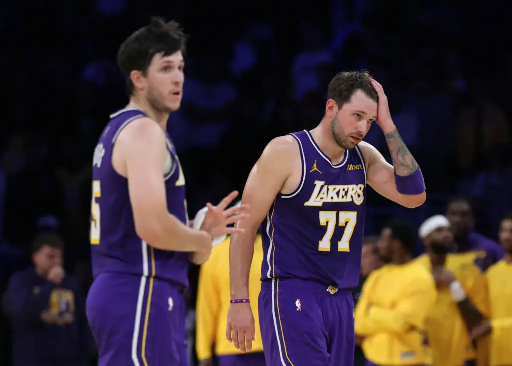 Lakers star Luka Doncic, right, and guard Austin Reaves react...
