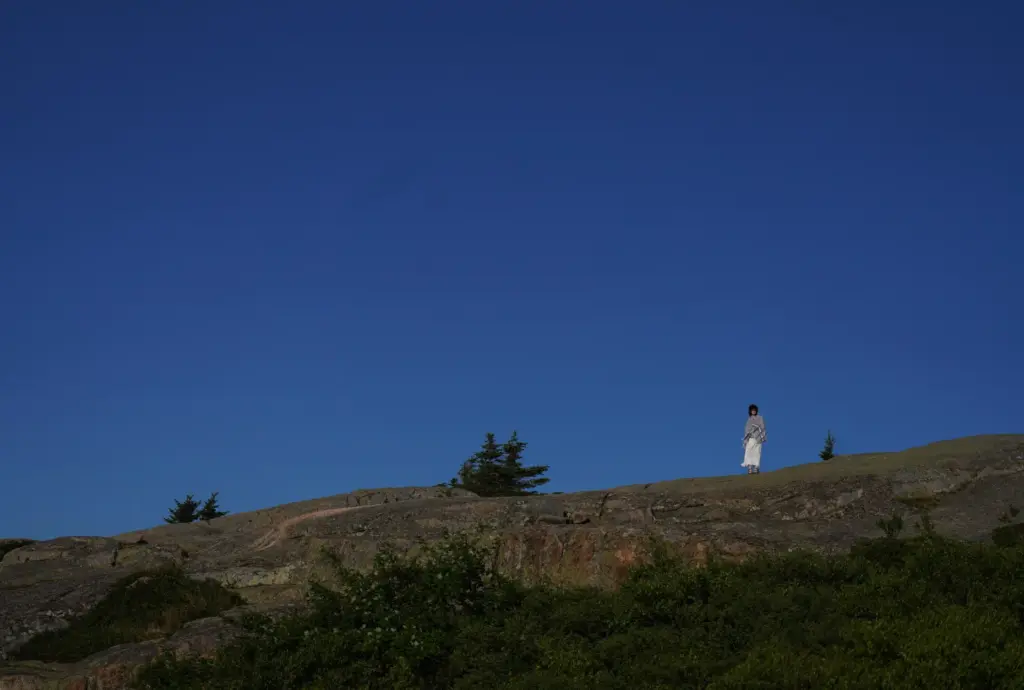 Lindsey Acker of Ohio stands at the summit of Cadillac...