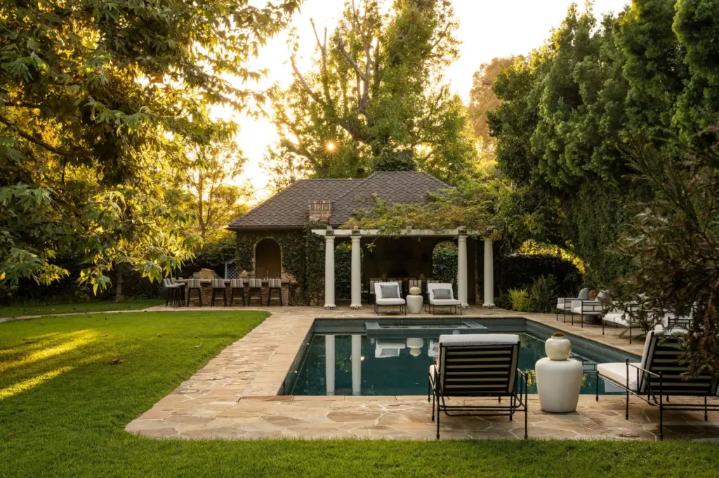 The backyard set up includes a pool and spa, an...