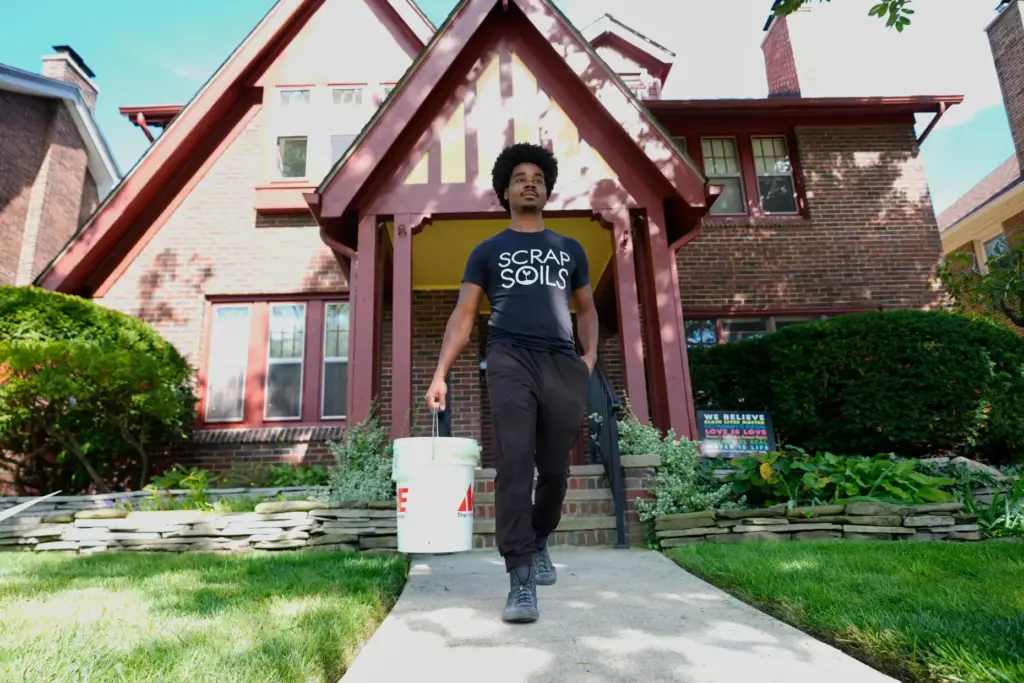 Ricky Blanding, founder of Scrap Soils, picks up compostable material...