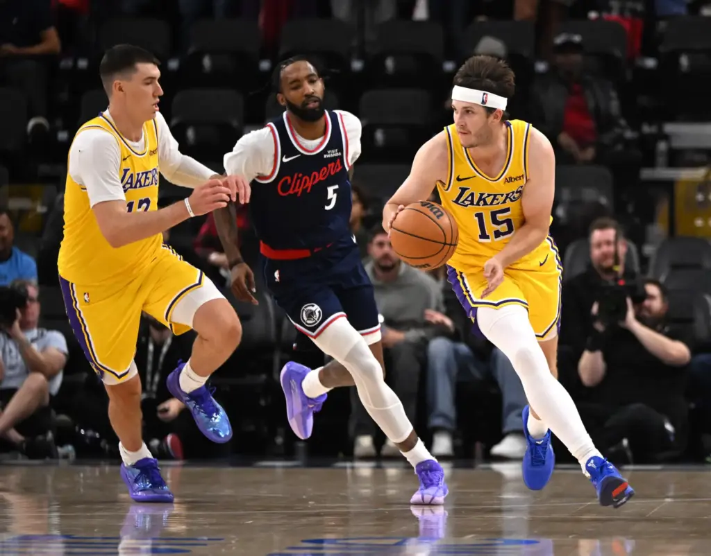 Lakers guard Austin Reaves handles the ball as forward Jake...