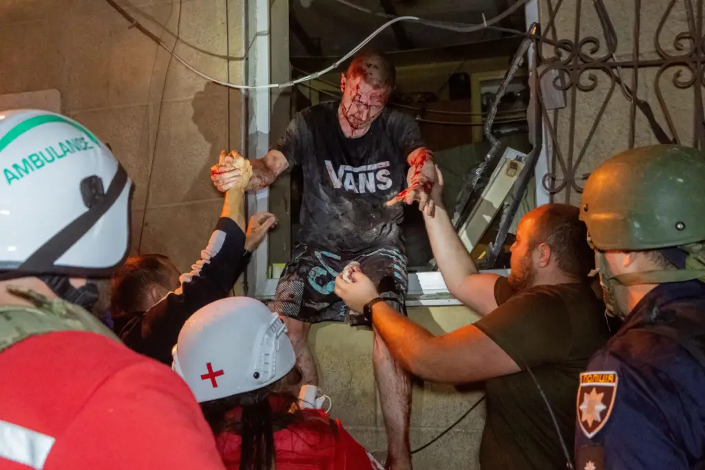 Rescuers evacuate an injured civilian after a residential building was hit following a Russian air attack.