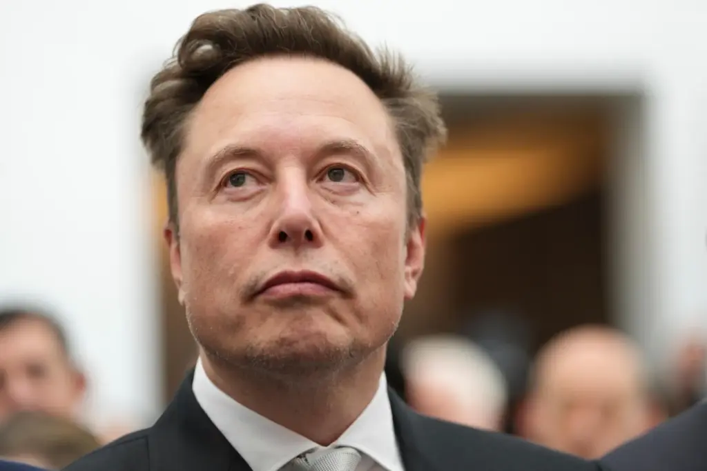 FILE – Elon Musk listens as President Donald Trump speaks...
