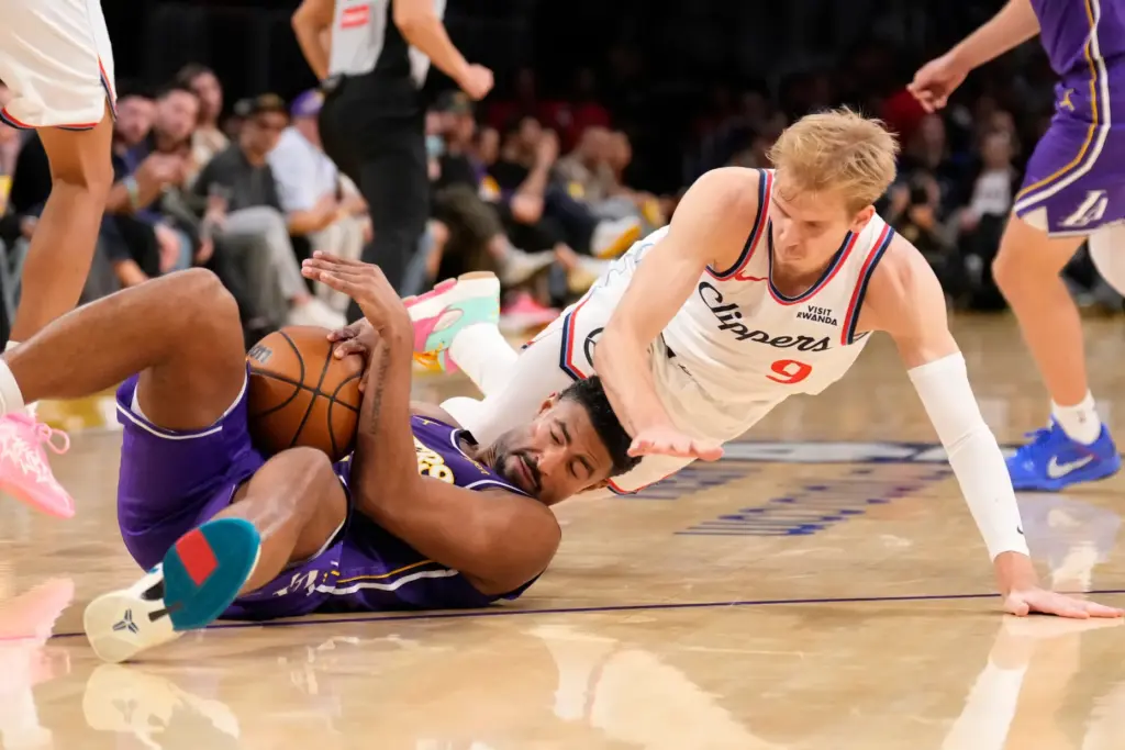 Lakers guard Quentin Grimes, left, scrambles for a loose ball...
