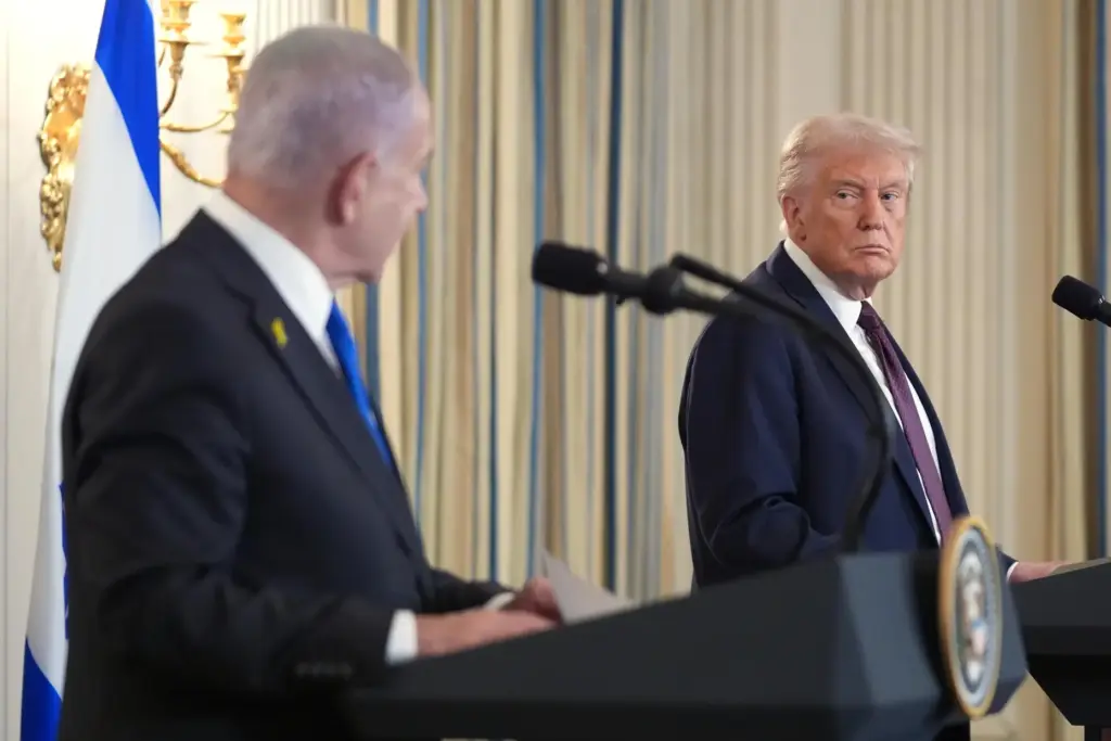 FILE – President Donald Trump, right, listens during a news...