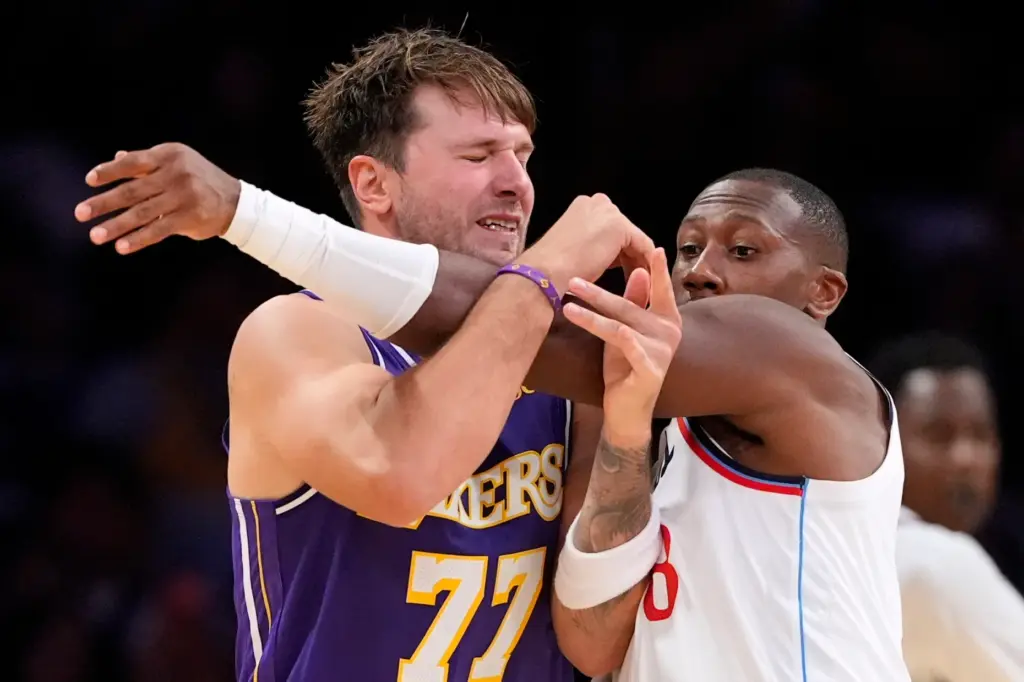 Lakers guard Luka Doncic, left, tries to get open to...
