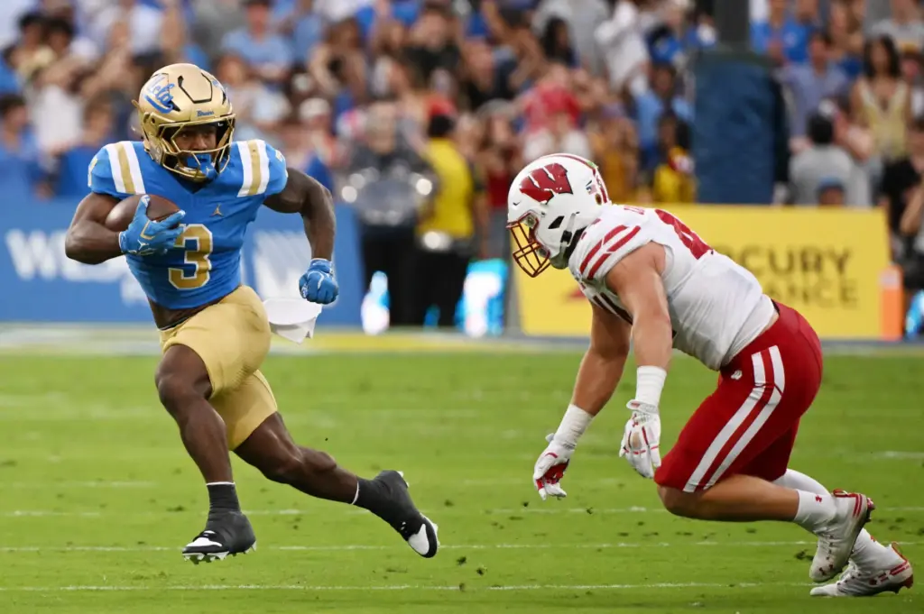 Running back Wayne Knight #3 of the UCLA Bruins runs...