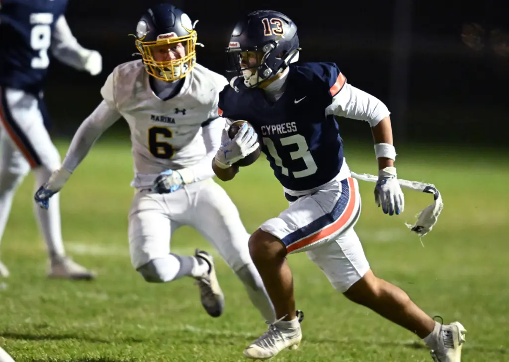 Ian Do #13 of Cypress runs past Nathan Kirk #6...