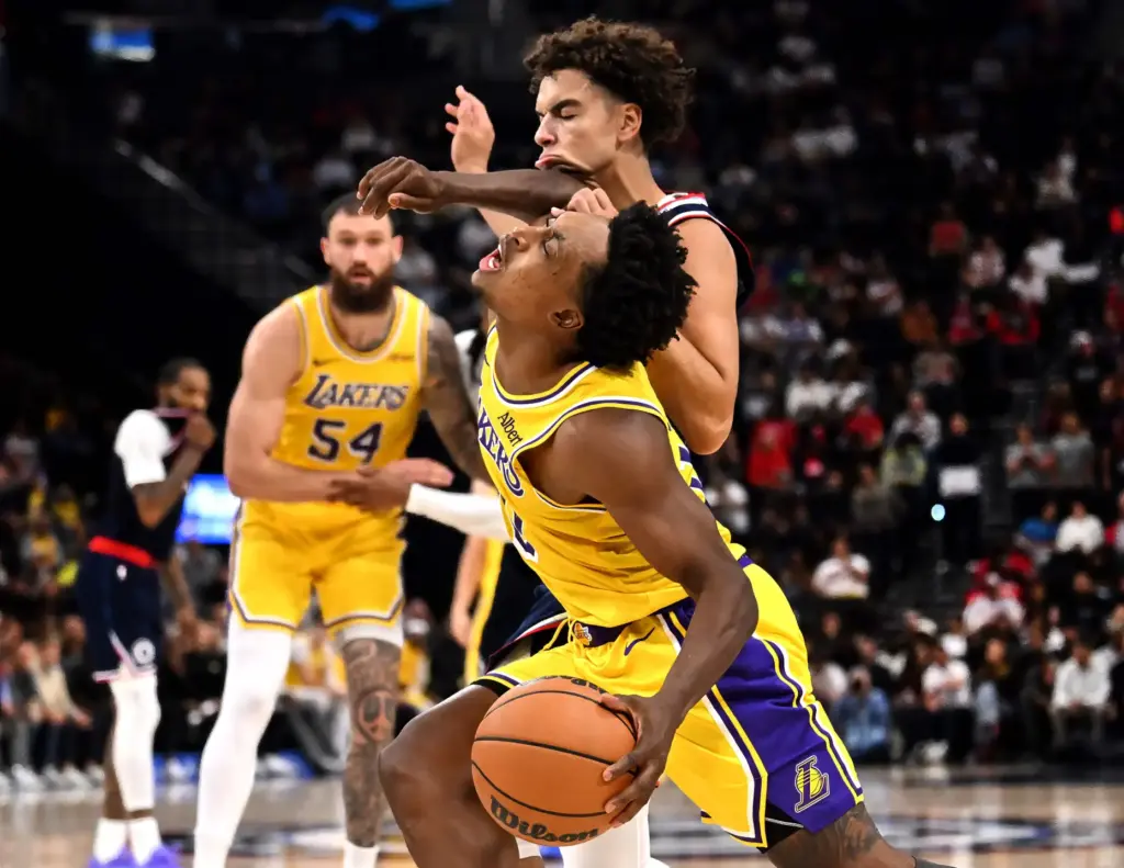 Lakers guard Collin Sexton, front, draws contact from Clippers rookie...