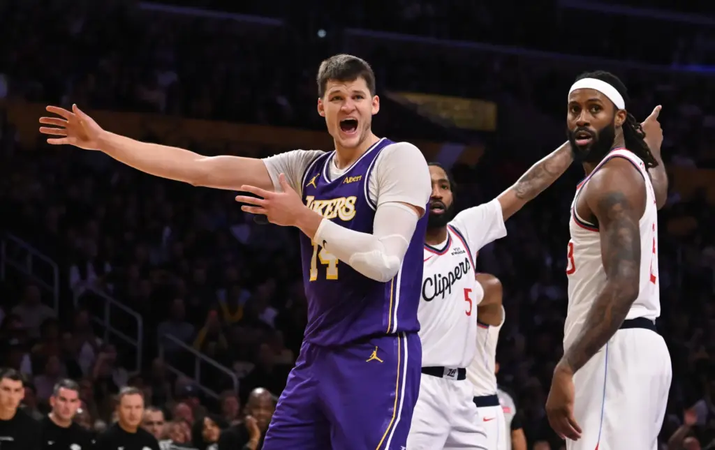 Lakers center Walker Kessler, left, reacts after being fouled by...