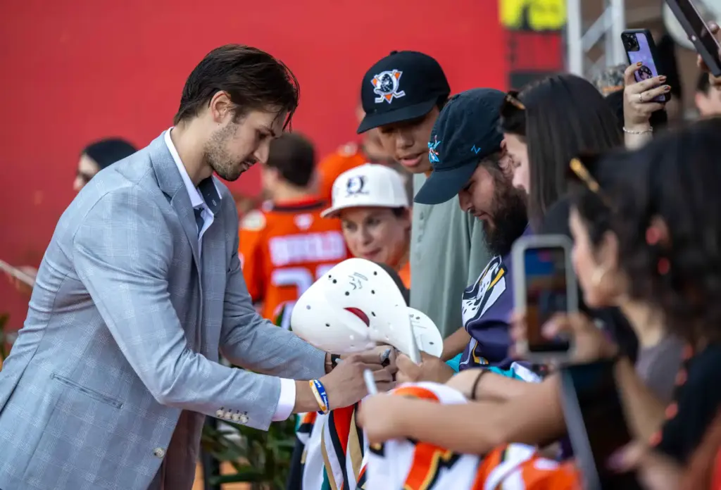 Ducks player Travis Mitchell signs autographs on the orange carpet...
